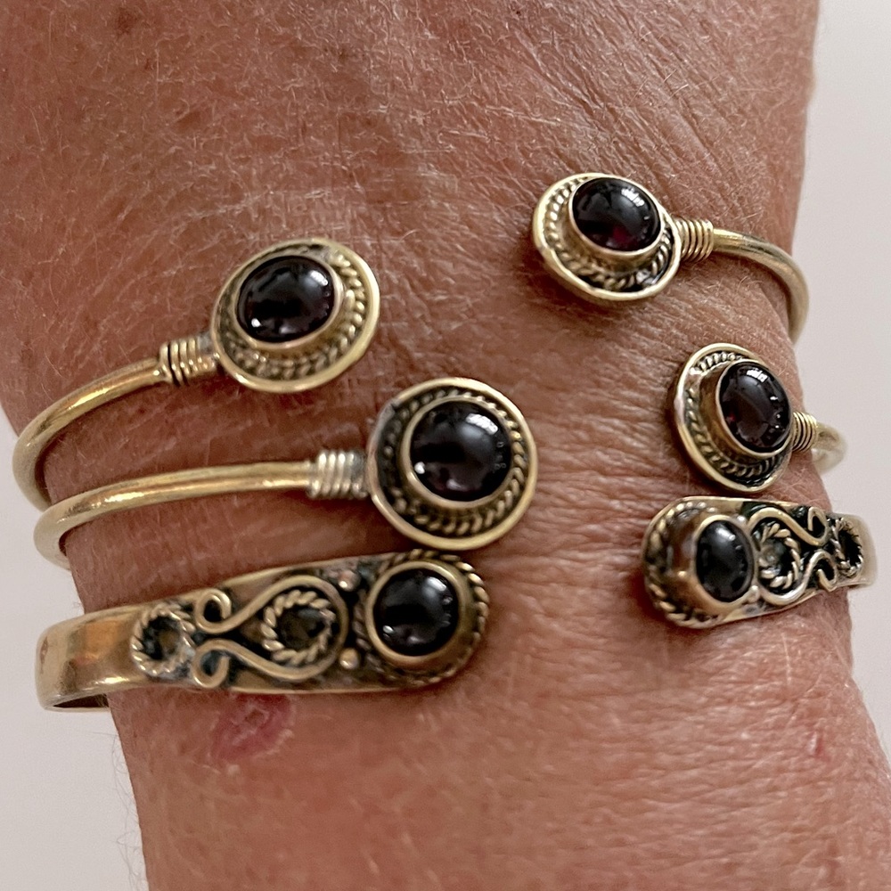 Three brass adjustable bangles with garnet semi precious stones